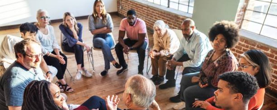 A group of people in a circle having a conversation